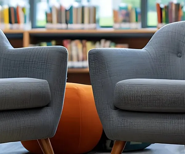 Fauteuils et pouf dans un espace détente de collectivité