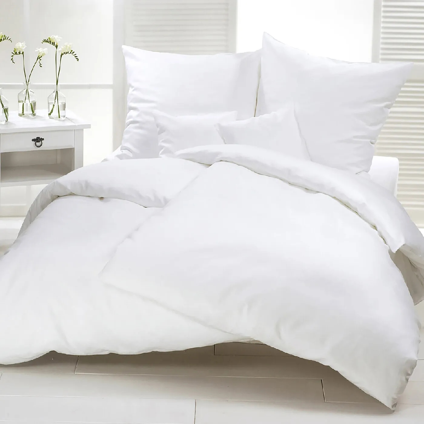 Parure de couette et oreillers blancs sur un lit d'hébergement